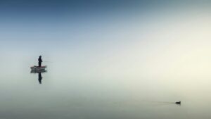 Solitary fisherman on a calm, still lake, reflecting a regulated nervous system
