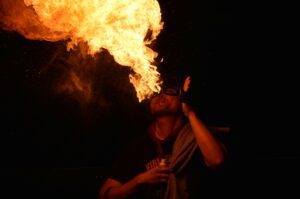 Performer breathing fire, symbolizing lung irritation linked to acid reflux